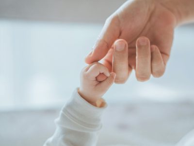 Säuglingshand in Mamas Hand