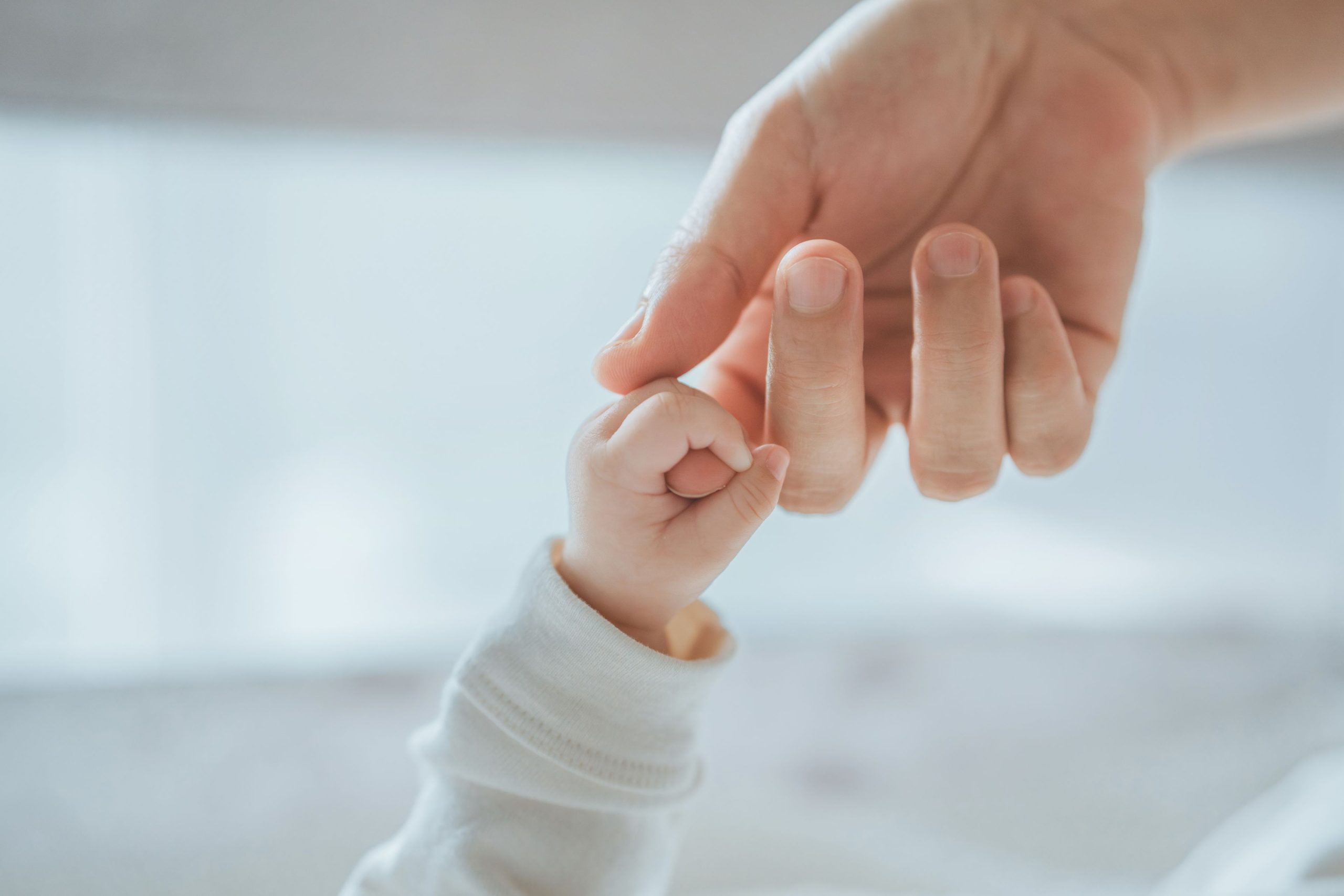 Säuglingshand in Mamas Hand